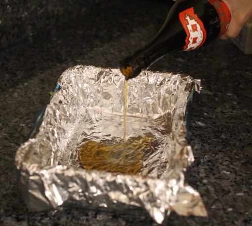 Pouring cooking wine onto foiled baking pan