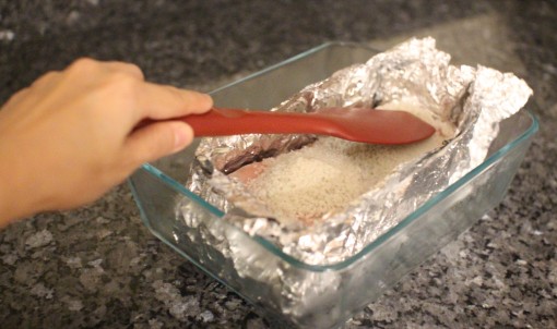 packing down coarse salt on pork belly